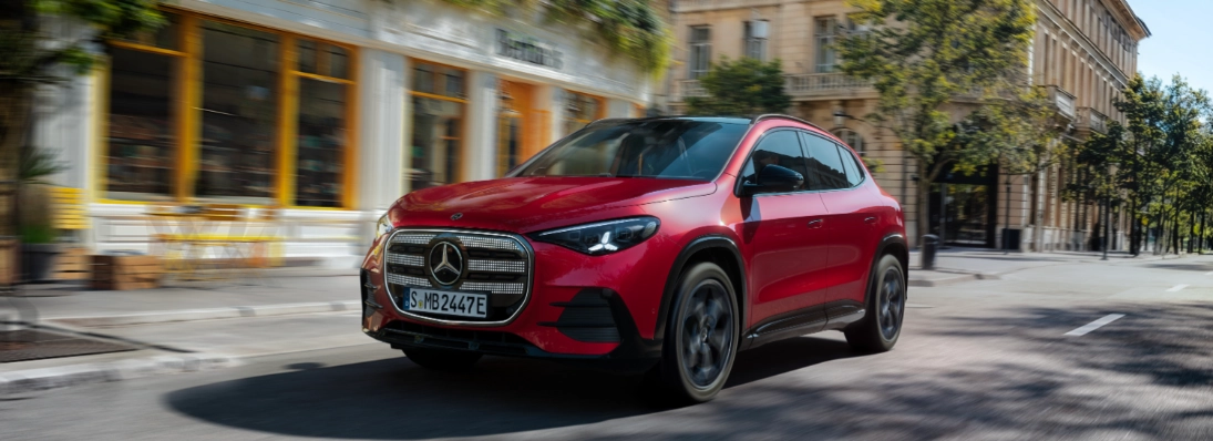 Nuova Mercedes GLA 2026 elettrica in movimento in città, vista tre quarti anteriore con calandra illuminata