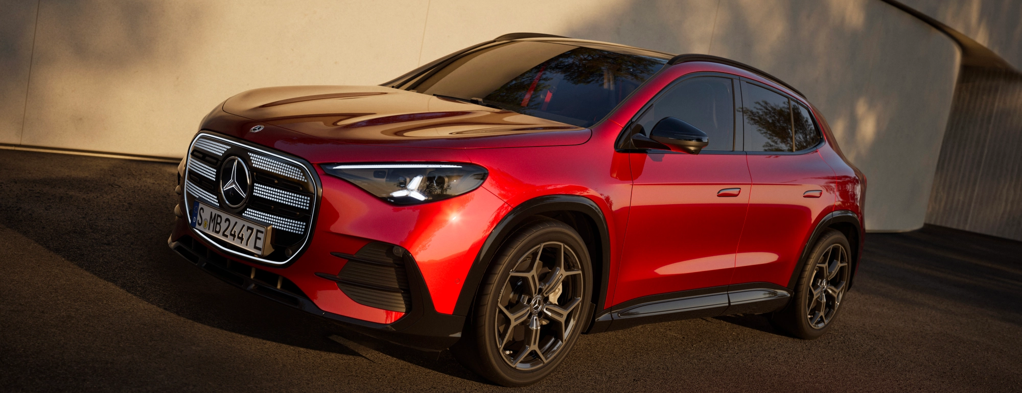 Nuova Mercedes GLA 2026 elettrica rossa, vista tre quarti anteriore con calandra a stella e cerchi neri