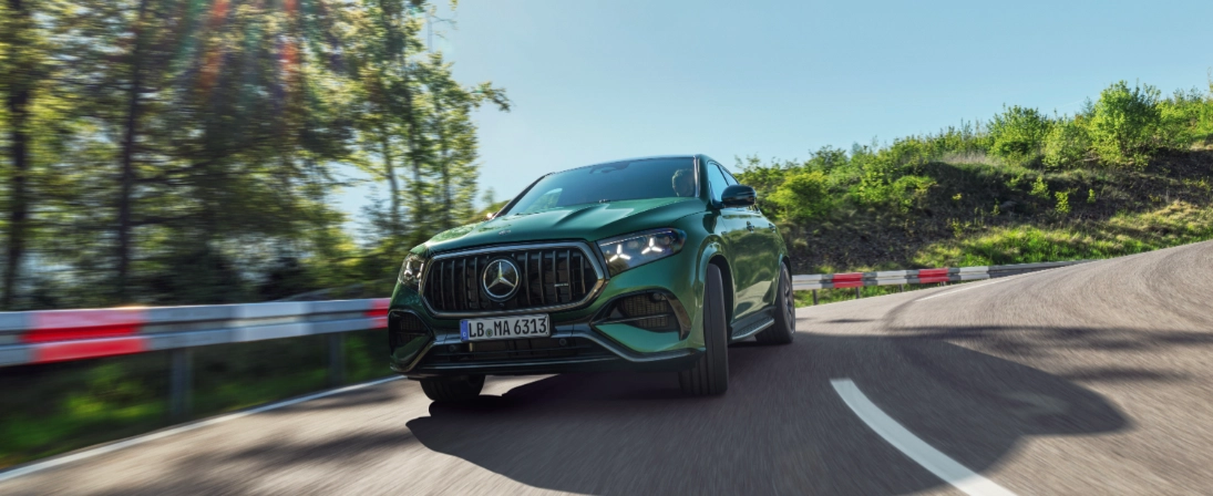Mercedes-AMG GLE Coupé verde in movimento su strada, con calandra AMG a listelli verticali